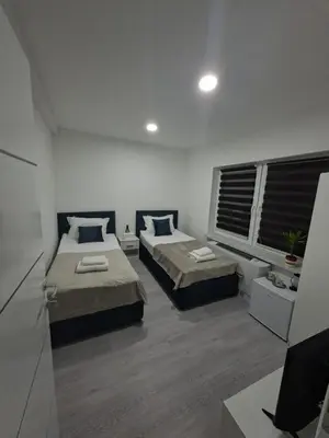 a bedroom with two beds and a window at Pansion Kod Brajlovica in Tuzla