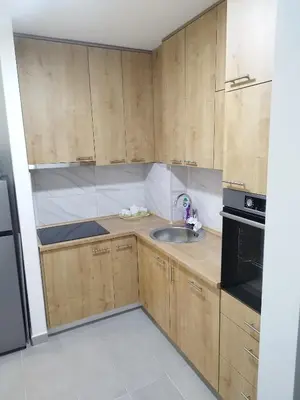 a kitchen with wooden cabinets and a sink at Apartman Harmony N&D in Starčevica
