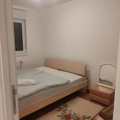 a small bedroom with a bed and a mirror at Ela in Banja Luka