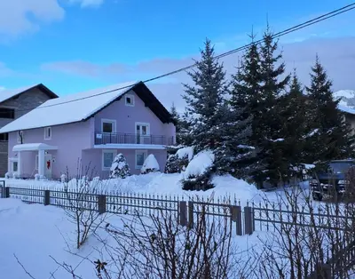 a white house with a fence in the snow at Biser Kupresa 2 in Kupres