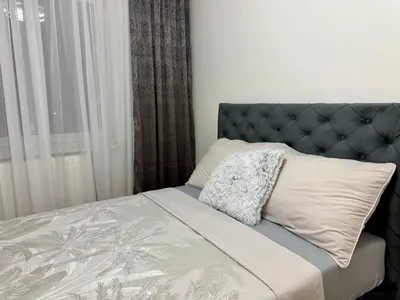 a bedroom with a bed with a blue headboard and a window at Apartmani Alexa in Banja Luka