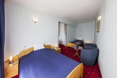 a bedroom with a bed and a couch and a table at Hotel Senad od Bosne in Prokosovići