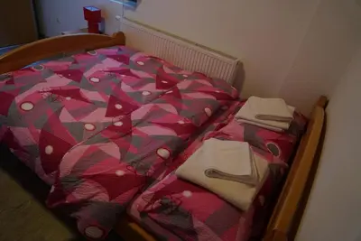 a bed with a colorful comforter and towels on it at Villa Tiha noc in Vlasic