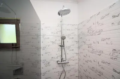 a shower in a bathroom with writing on the wall at Oasis of peace in Bihać