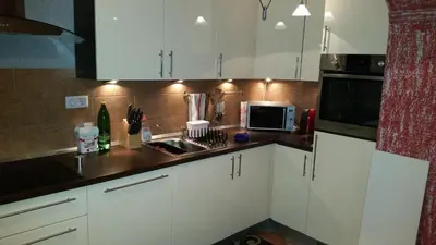 a kitchen with white cabinets and a sink and a microwave at Sana apartment in Sanski most