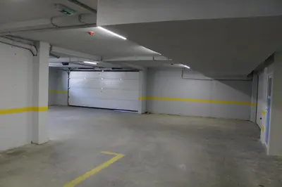an empty parking garage with white garage doors at VIP 2 Apartment in Visoko
