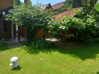 a stuffed animal sitting in the grass in front of a house at Soba Dujaković in Banja Vrućica