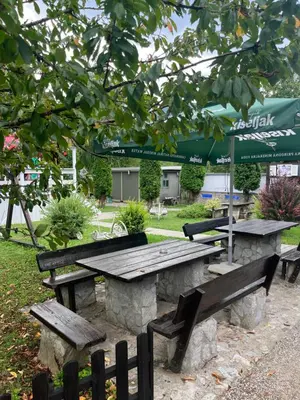 a picnic table and benches in a park at Hotel Neron Bihać in Lohovo