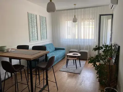a living room with a blue couch and a table at Zeus Apartment in Banja Luka